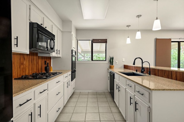 kitchen with black appliances, a peninsula, a sink, and a wealth of natural light