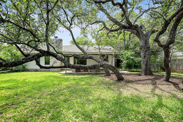 view of front of house featuring fence, a front lawn, and stucco siding