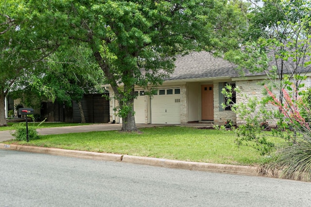 view of front facade with driveway, stone siding, an attached garage, a shingled roof, and a front yard