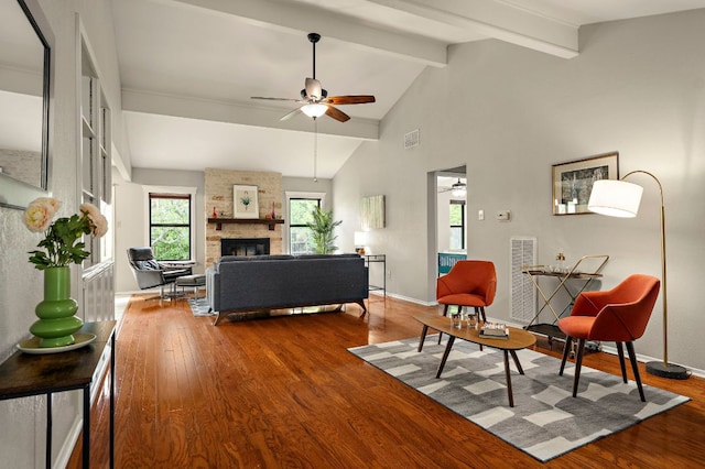 living area with lofted ceiling with beams, a ceiling fan, wood finished floors, and visible vents