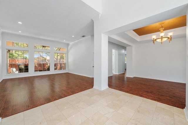 unfurnished living room featuring crown molding, a chandelier, and light wood finished floors