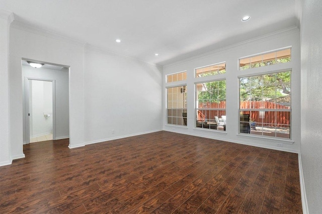 spare room featuring baseboards, wood finished floors, recessed lighting, and crown molding