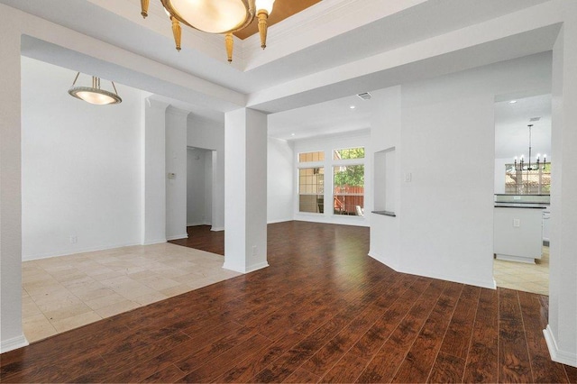 unfurnished room featuring baseboards, recessed lighting, a chandelier, wood finished floors, and a raised ceiling