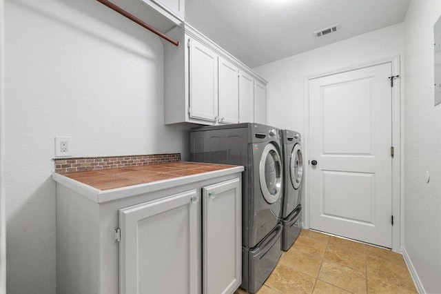 laundry room featuring cabinet space, visible vents, washing machine and clothes dryer, and baseboards