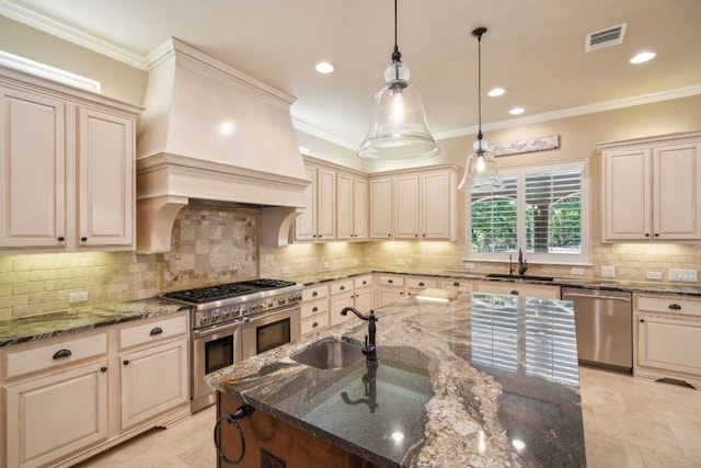 1113 Lions Lair, Leander, TX 78641 - kitchen with appliances with stainless steel finishes, cream cabinets, dark stone countertops, crown molding, and hanging light fixtures