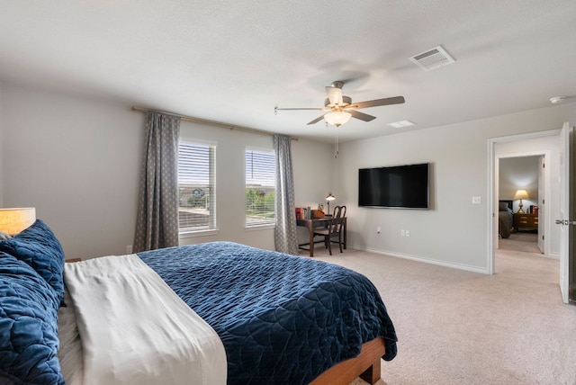 bedroom featuring ceiling fan, light carpet, visible vents, and baseboards
