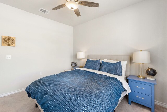 carpeted bedroom featuring baseboards, a ceiling fan, and visible vents