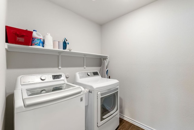 washroom with baseboards, independent washer and dryer, laundry area, and dark wood-style flooring