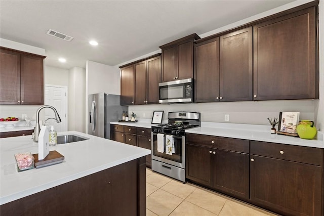 8060 Massa Dr, Round Rock, TX 78665 - kitchen featuring stainless steel appliances, light tile patterned floors, light countertops, dark brown cabinets, and recessed lighting