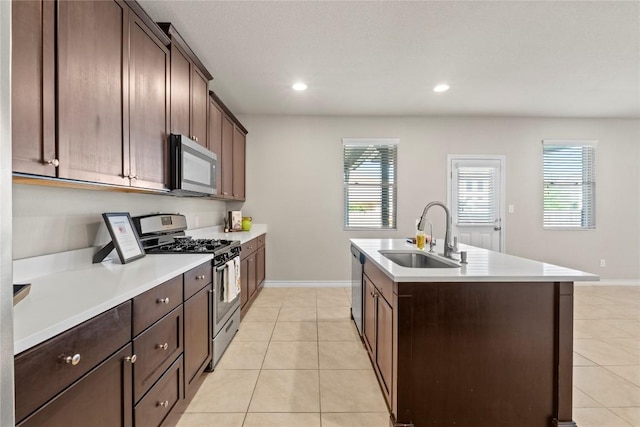 8060 Massa Dr, Round Rock, TX 78665 - kitchen featuring appliances with stainless steel finishes, light tile patterned floors, a kitchen island with sink, plenty of natural light, and recessed lighting
