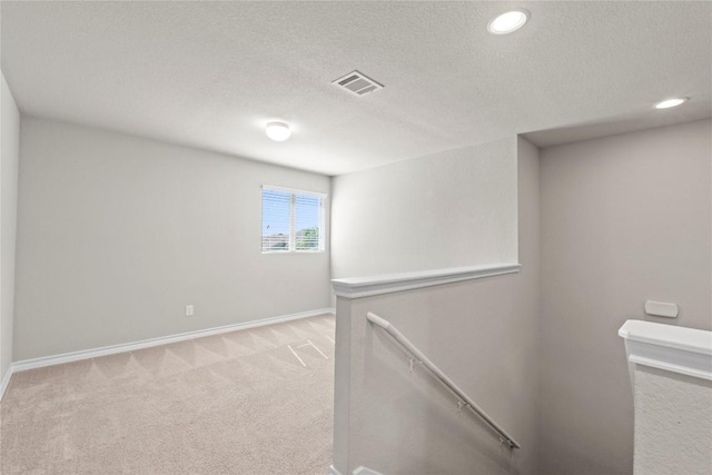 8060 Massa Dr, Round Rock, TX 78665 - hall with an upstairs landing, light carpet, a textured ceiling, and recessed lighting