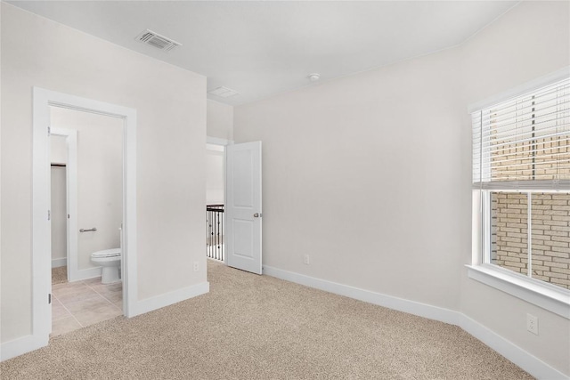 unfurnished bedroom featuring visible vents, carpet flooring, baseboards, and connected bathroom