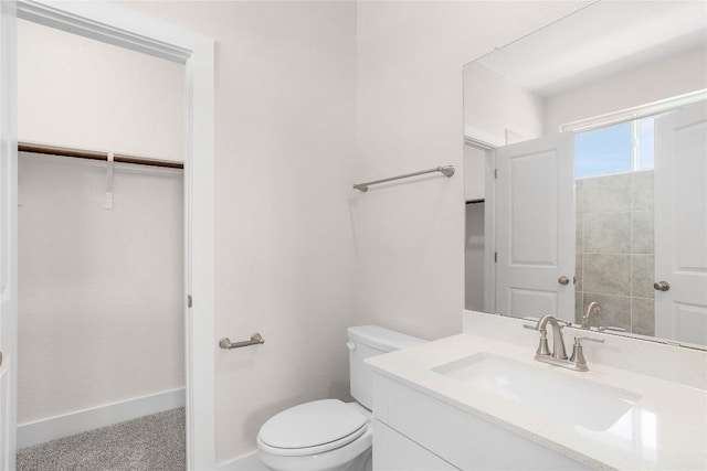 bathroom featuring baseboards, vanity, and toilet