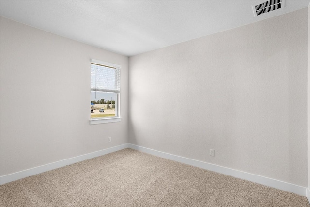 empty room featuring visible vents, baseboards, and carpet flooring