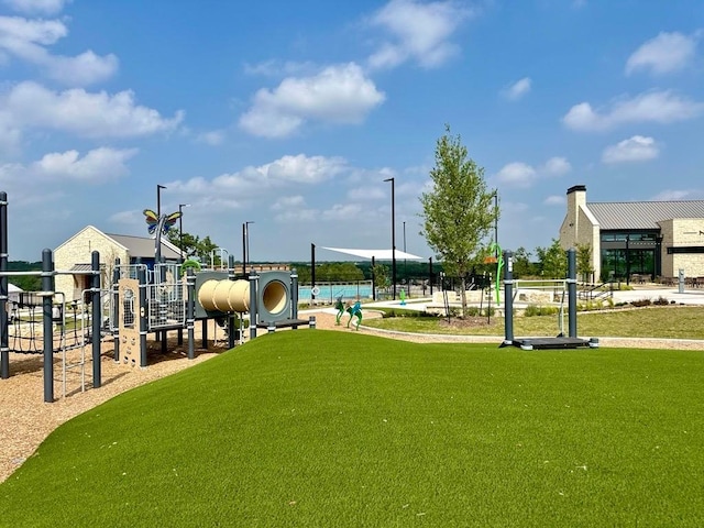 view of property's community featuring playground community, heating fuel, and a yard