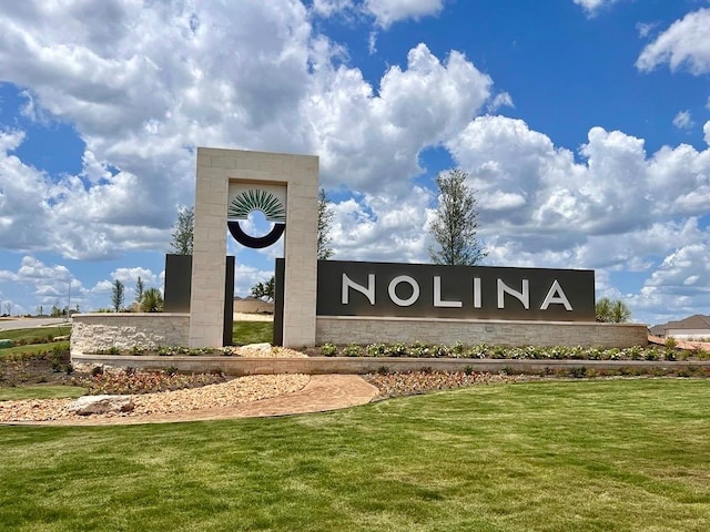 community sign featuring a lawn