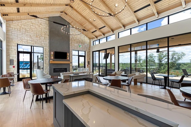 101 Golden Sage Ave, Georgetown, TX 78633 - kitchen with a wooden ceiling with exposed beams, high vaulted ceiling, light wood-style floors, a large fireplace, and a chandelier