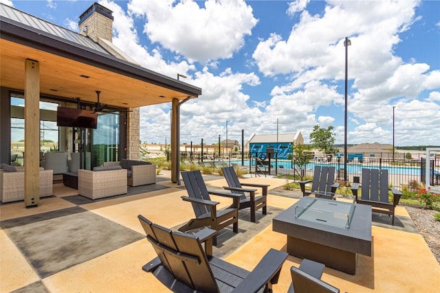 view of patio / terrace with an outdoor living space, ceiling fan, fence, and a community pool