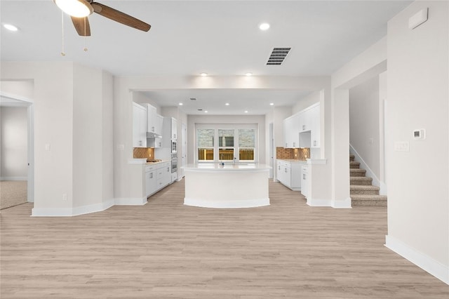 unfurnished living room featuring ceiling fan, baseboards, visible vents, and light wood-style flooring