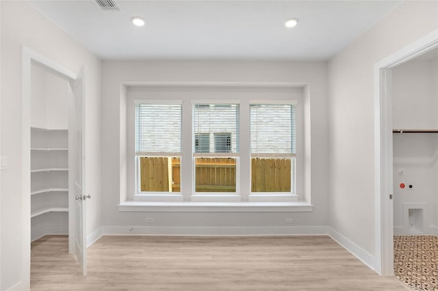 spare room with recessed lighting, light wood finished floors, and baseboards