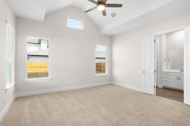 unfurnished bedroom featuring light carpet, vaulted ceiling, visible vents, and baseboards