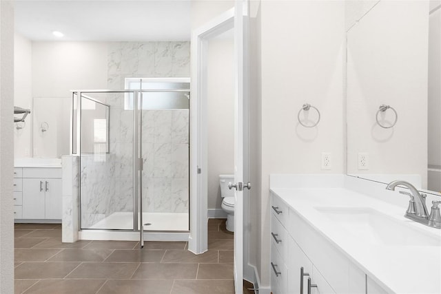 full bath with tile patterned flooring, toilet, vanity, and a marble finish shower