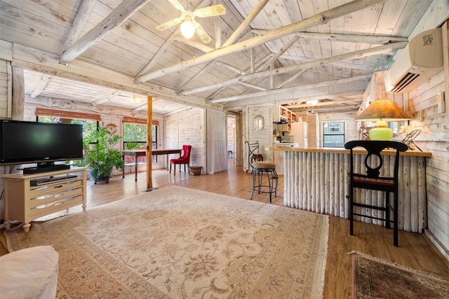 living area featuring wood ceiling, lofted ceiling with beams, hardwood / wood-style floors, and a wall mounted AC