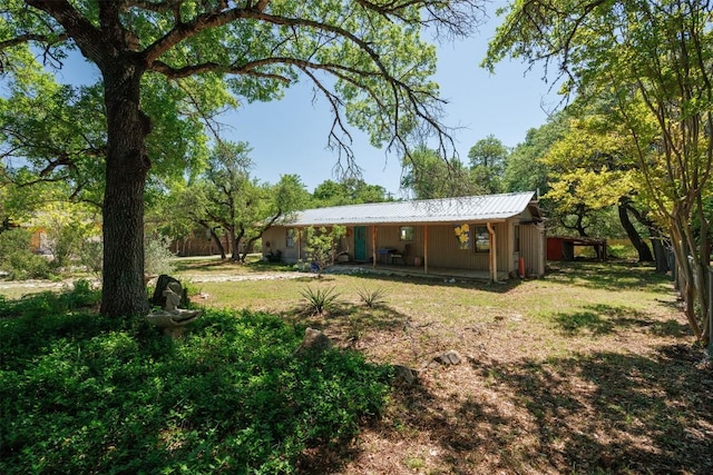 rear view of house with a yard and metal roof