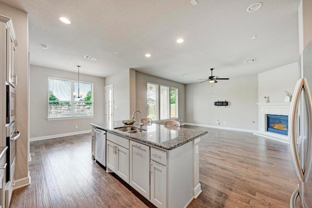 4228 Hannover Way, Round Rock, TX 78681 - kitchen featuring stainless steel appliances, dark stone countertops, wood finished floors, a ceiling fan, and a sink