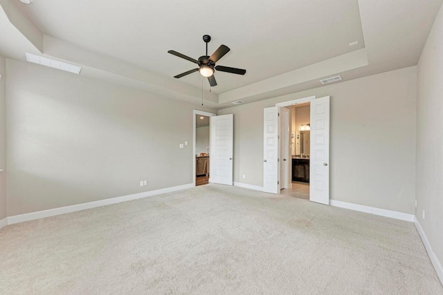 4228 Hannover Way, Round Rock, TX 78681 - unfurnished bedroom featuring a raised ceiling, light colored carpet, ensuite bath, and ceiling fan