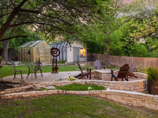 9200 Collingwood Dr, Austin, TX 78748 - fenced backyard featuring an outdoor fire pit, a patio, an outdoor structure, and a greenhouse