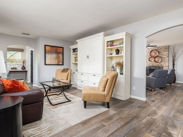 9200 Collingwood Dr, Austin, TX 78748 - living area with arched walkways, wood finished floors, a brick fireplace, and a ceiling fan