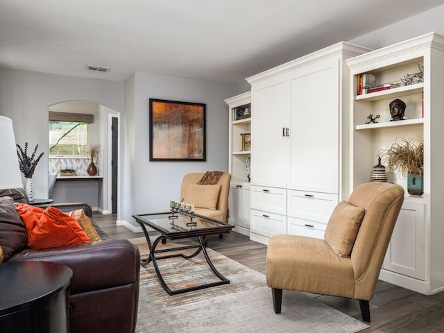 9200 Collingwood Dr, Austin, TX 78748 - living room featuring arched walkways, dark wood finished floors, and baseboards