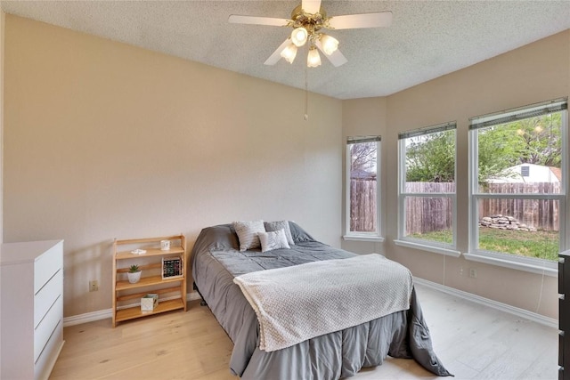3100 Jubilee Trl, Austin, TX 78748 - bedroom with multiple windows, light wood-style floors, baseboards, and a textured ceiling
