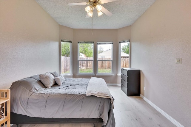 3100 Jubilee Trl, Austin, TX 78748 - bedroom with a textured wall, a textured ceiling, light wood-type flooring, baseboards, and a ceiling fan