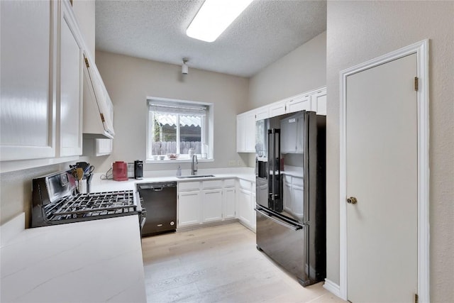 3100 Jubilee Trl, Austin, TX 78748 - kitchen featuring black appliances, a sink, white cabinetry, light wood-type flooring, and a textured ceiling