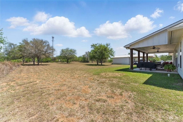 view of yard with ceiling fan and a patio area