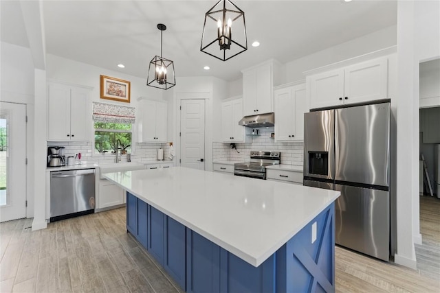 kitchen featuring light countertops, light wood-style floors, appliances with stainless steel finishes, and under cabinet range hood