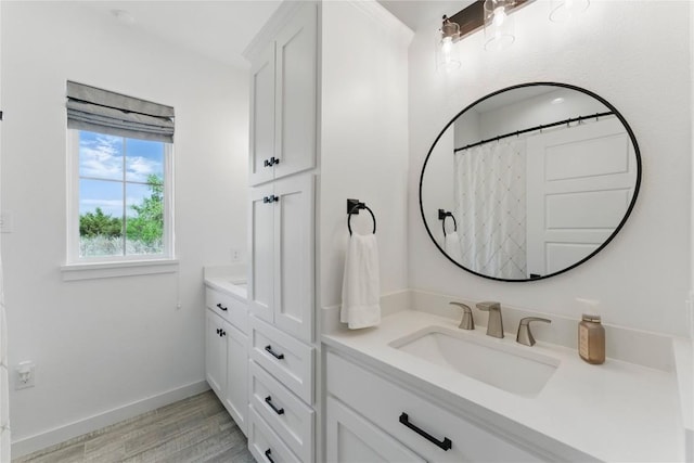 full bathroom featuring baseboards, wood finished floors, and vanity
