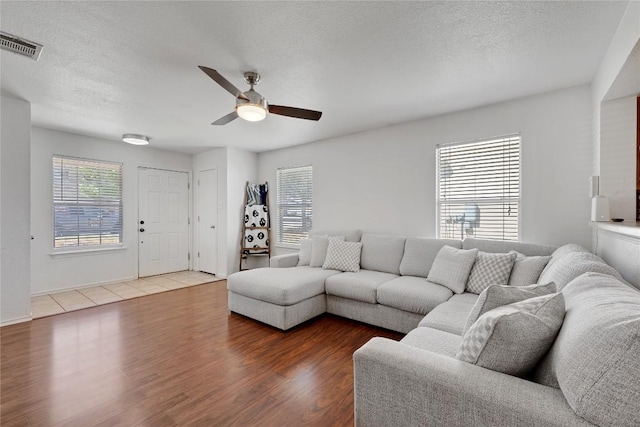 6801 Campina Xing, Del Valle, TX 78617 - living room featuring ceiling fan, wood finished floors, and a textured ceiling