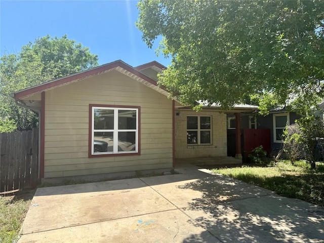 rear view of property featuring a patio area and fence