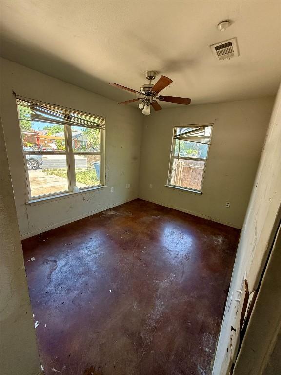 unfurnished room with concrete floors, visible vents, and a ceiling fan