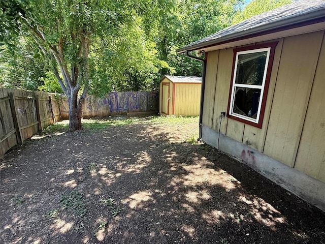 view of yard featuring a storage shed, an outbuilding, and a fenced backyard