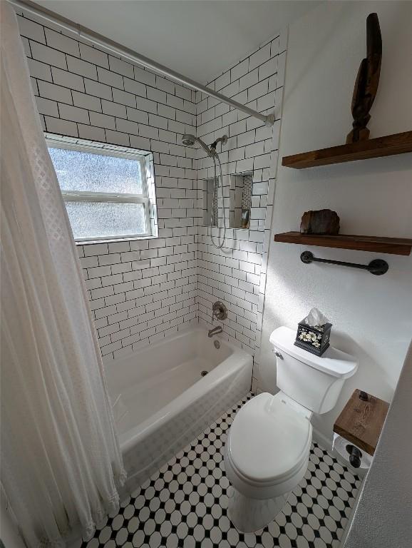 bathroom with shower / tub combo and toilet