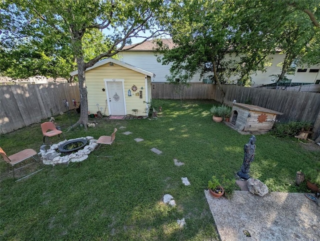 view of yard with a storage shed, an outdoor structure, and an outdoor fire pit