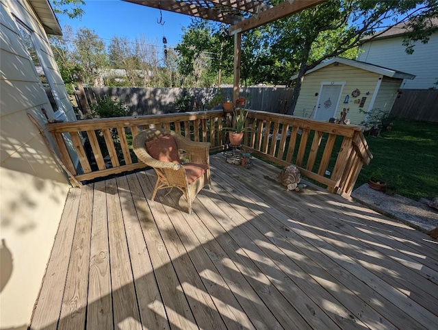 deck with an outdoor structure, a pergola, a fenced backyard, and a shed