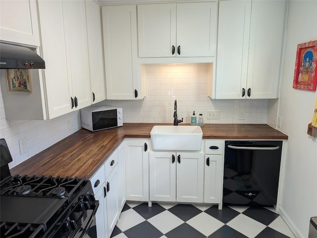 kitchen featuring a sink, tile patterned floors, black appliances, and butcher block counters