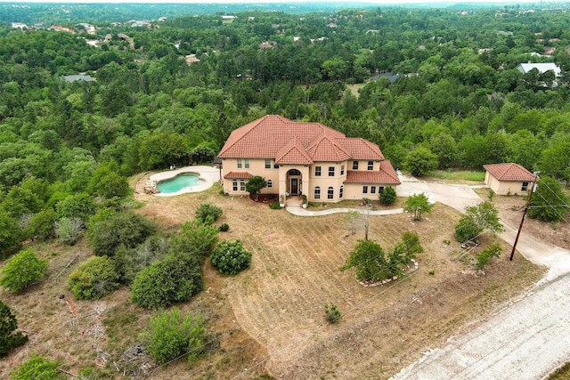 birds eye view of property featuring a forest view