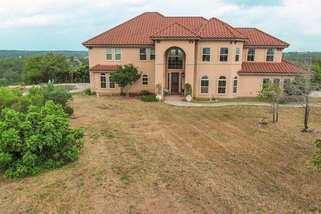 134 River Forest Dr, Bastrop, TX 78602 - mediterranean / spanish-style house featuring stucco siding, a tiled roof, and a front lawn
