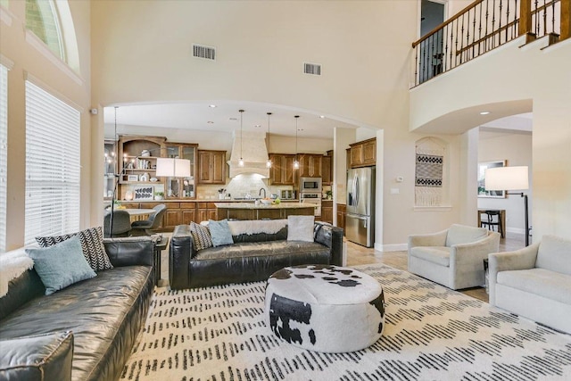 8813 Fescue Ln, Austin, TX 78738 - living area with a towering ceiling, arched walkways, and baseboards
